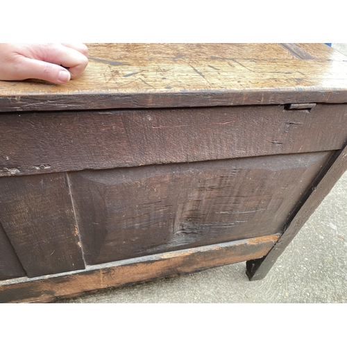 9 - Large antique oak hinged wooden chest with heavy carved detailing to front panel