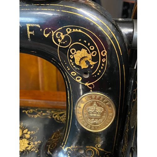 57 - A PFAFF antique sewing machine in black with gold trim serial number 164134 complete with wooden box... 