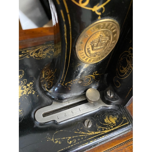 57 - A PFAFF antique sewing machine in black with gold trim serial number 164134 complete with wooden box... 