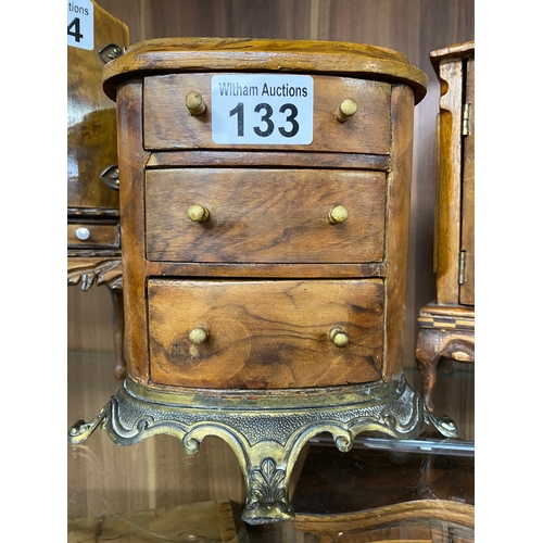 133 - A handcrafted wooden miniature oval chest of drawers with a metal base