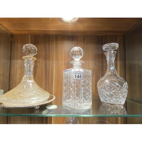 145 - A group of cut glass decanters in different sizes, cuts and styles together with a plateware tray