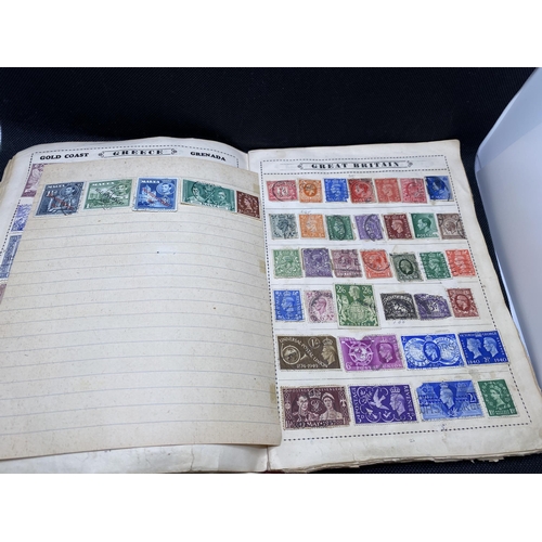 157 - The Globe stamp album, containing stamps from around the world together with a Strand stamp album to... 