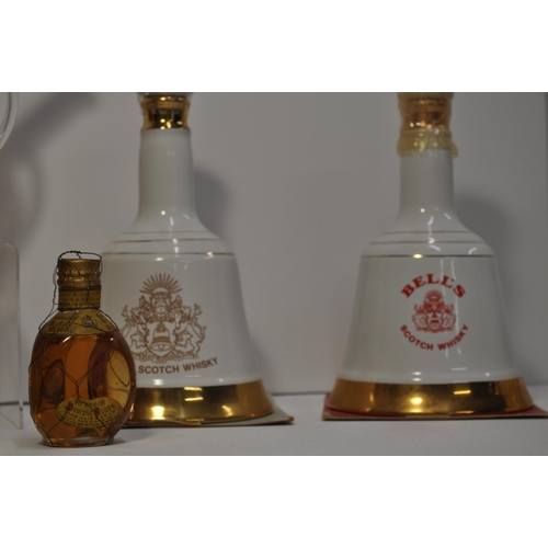 63 - A collection of different bottles of whisky's including Stylish Whisky globe bottle, bells and a bot... 