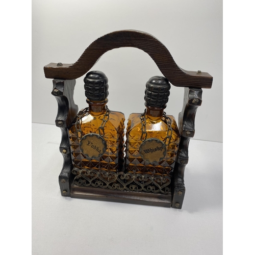 64 - Vintage amber glass decanter set, corks in tact, housed in a rustic wooden caddy