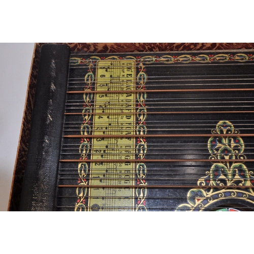 45 - A 6 chord concert guitar-zither with a bird design and other border decoration beneath strings, toge... 