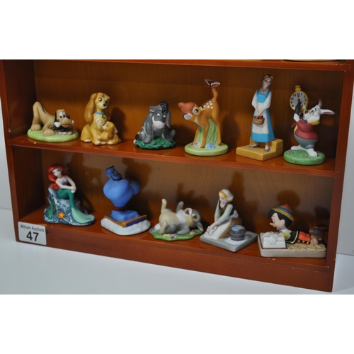 47 - A wooden display shelving unit displaying various ceramic Disney characters, stamped Disney (some st... 