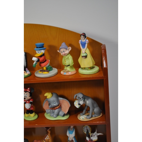 47 - A wooden display shelving unit displaying various ceramic Disney characters, stamped Disney (some st... 