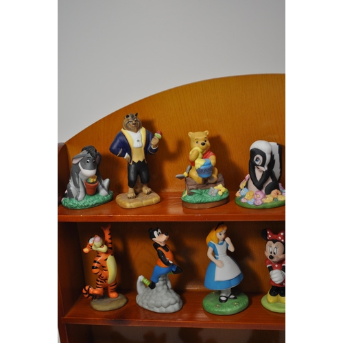 47 - A wooden display shelving unit displaying various ceramic Disney characters, stamped Disney (some st... 