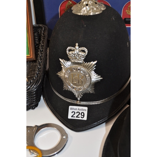 229 - A collection of police items to include a Essex Police hat plus one other, framed and unframed badge... 