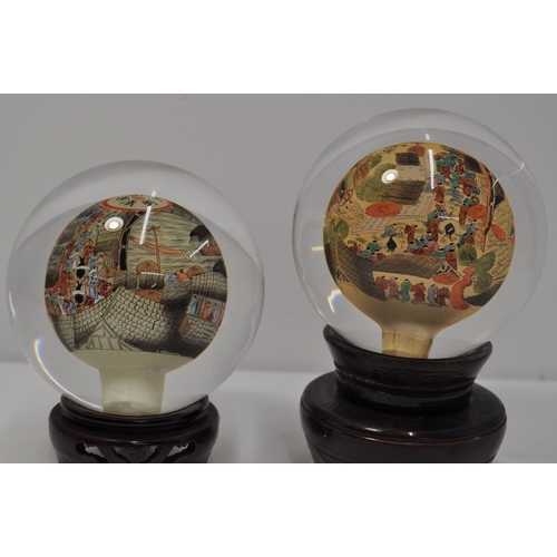 22 - Two vintage oriental reverse hand painted glass sphere/globe on stands, with signatures, approx diam... 