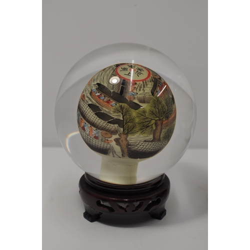 22 - Two vintage oriental reverse hand painted glass sphere/globe on stands, with signatures, approx diam... 