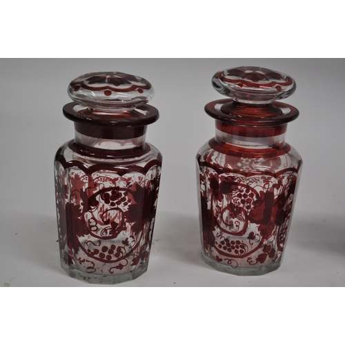 29 - A selection of glassware to include a pair of ruby flash glass pickle jars with vine decoration, a c... 