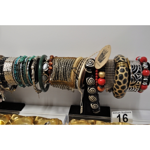 16 - A large quantity of costume jewellery to include brooches, pendants, rings, colourful bangle/bracele... 