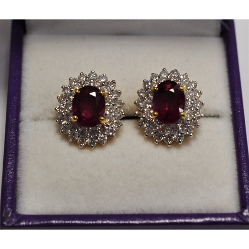 18ct yellow gold oval cut ruby earrings surrounded by double row of brilliant cut diamonds, approx. weight of ruby 1.60ct total, diamonds are approx. 0.80ct in total, approx. length overall 15mm. Please also see Lot 42 for matching cluster ring