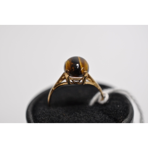 44 - A 9ct yellow gold ring with cabochon tiger eye stone in raised mount, hallmarked London approx. gros... 