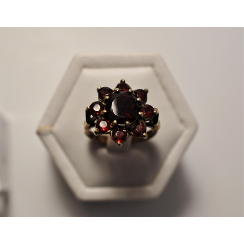 48 - 9ct yellow gold rings (x2), one featuring a red stone cluster approx. size O, one with oval cabochon... 