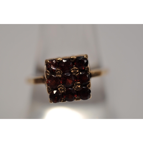 60 - 9ct yellow gold red gemstone ring in a square form design, A/F, approx. size P