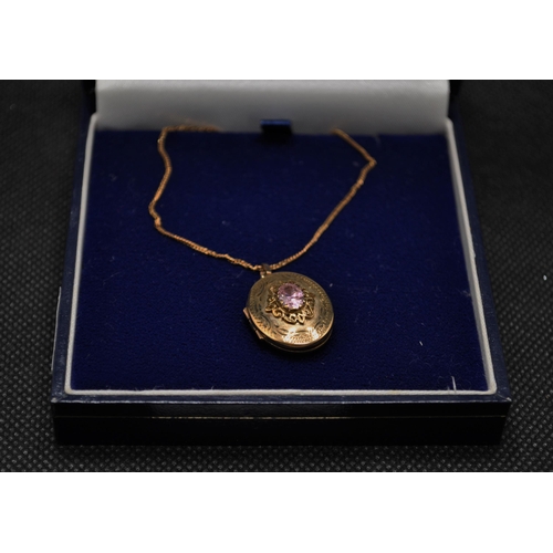 81 - A 9ct gold locket with central pink stone to design which measures approx. L2cm, with 18