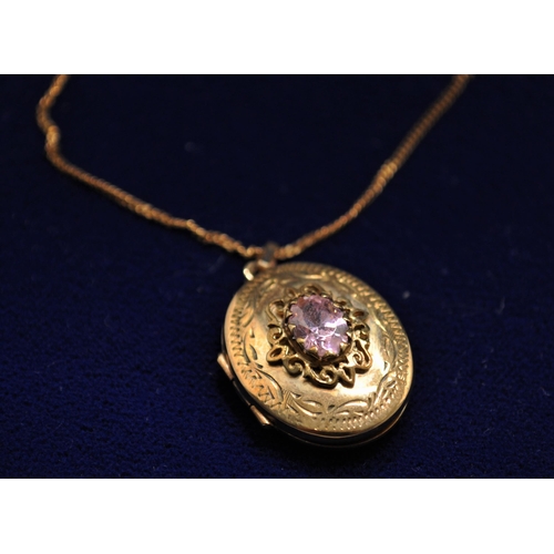 81 - A 9ct gold locket with central pink stone to design which measures approx. L2cm, with 18