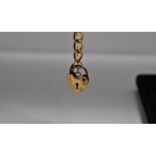 92 - 9ct yellow gold link bracelet with safety chain together with two 9ct gold charms in the form of con... 