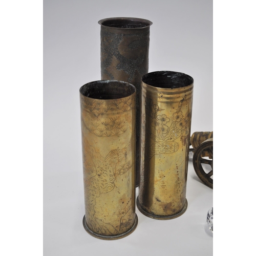 116 - A collection of trench art items to include three WWI artillery shells, one with a hammered leaf des... 