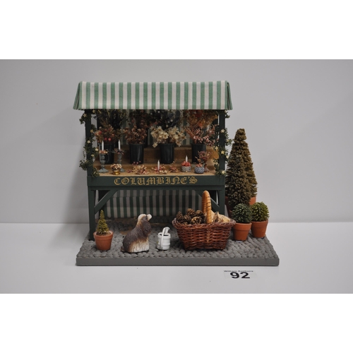 92 - Diorama scene of a flower stand with various items displayed and barn shed scene with various items ... 