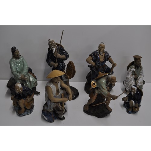 43 - A group of 8 mud men figures in various poses approx. height of tallest figure 29cm