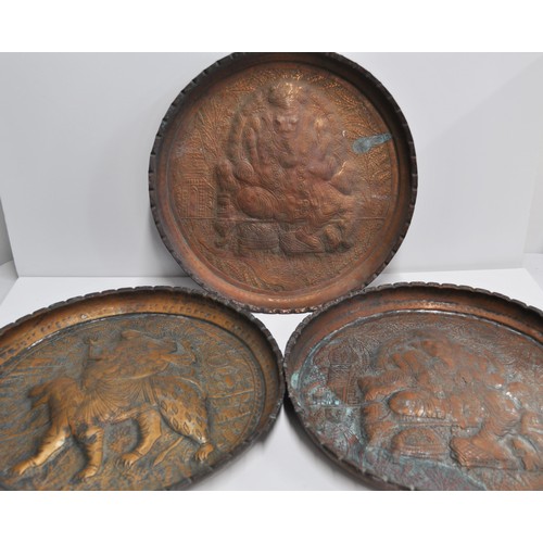 60 - A collection of three Indian copper trays with pressed designs, two of Ganesha and one of Durga ridi... 