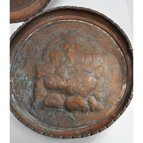 60 - A collection of three Indian copper trays with pressed designs, two of Ganesha and one of Durga ridi... 