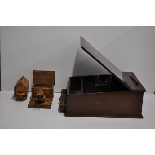 110 - A mahogany writing slope together with a hand-carved cigarette dispenser depicting a bird on the bob... 