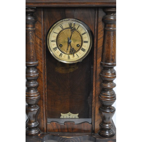 175 - Antique Vienna Wall Clock in walnut design casing, complete with pendulum and key. Ornate eagle desi... 