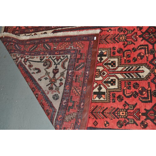 185 - Woven rug in Aztec design, tones of Red, Orange and Beige with abstract margin. approx. 204cm x 127c... 