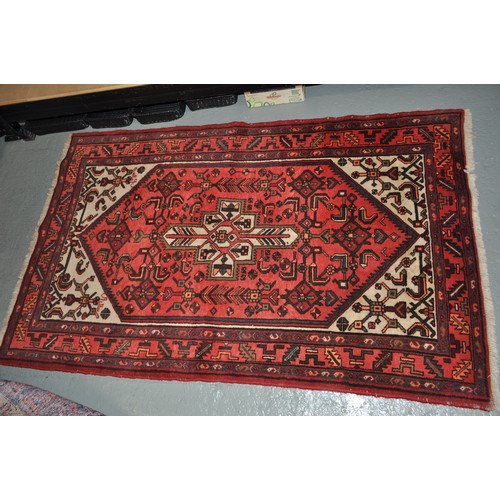 185 - Woven rug in Aztec design, tones of Red, Orange and Beige with abstract margin. approx. 204cm x 127c... 