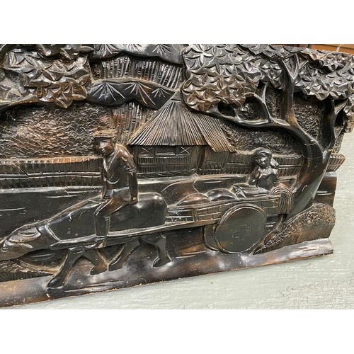 216 - Hardwood carved panel depicting a rural scene of a bullock cart