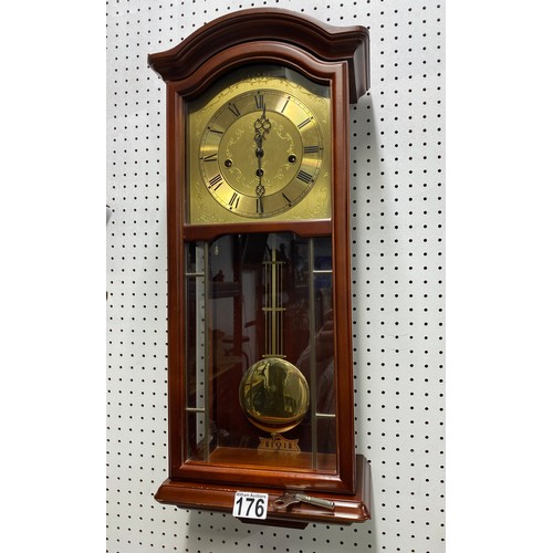 176 - Cased wall clock with brass coloured dial and roman numerals, includes original purchase receipt fro... 