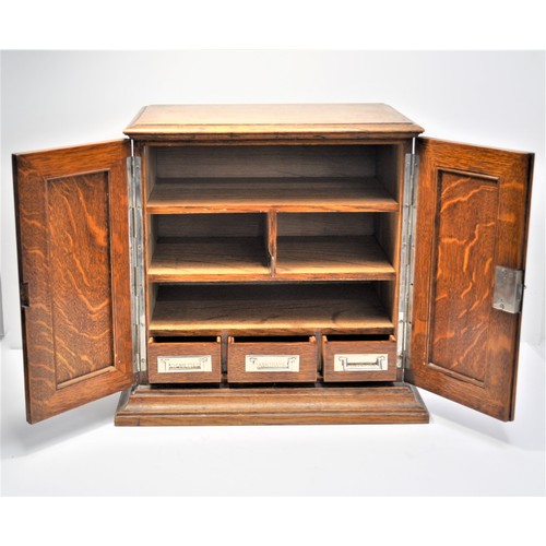 6 - A Wooden smokers cabinet with oak panel doors. The three drawers to the interior labelled cigarettes... 