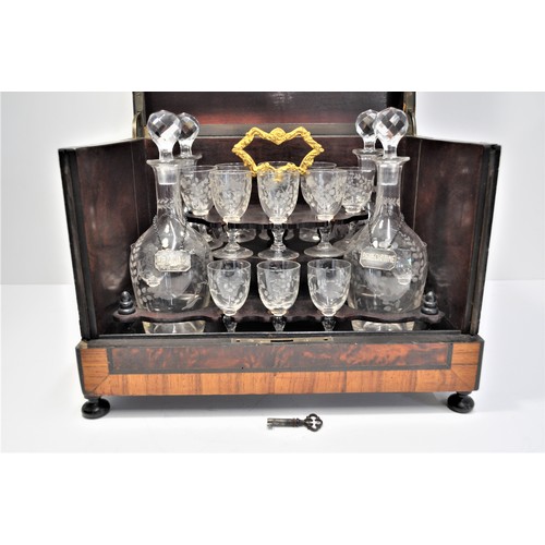 10 - Liqueur tantalus /cabinet containing four decanters, x16 glasses with flower designs. Top features m... 