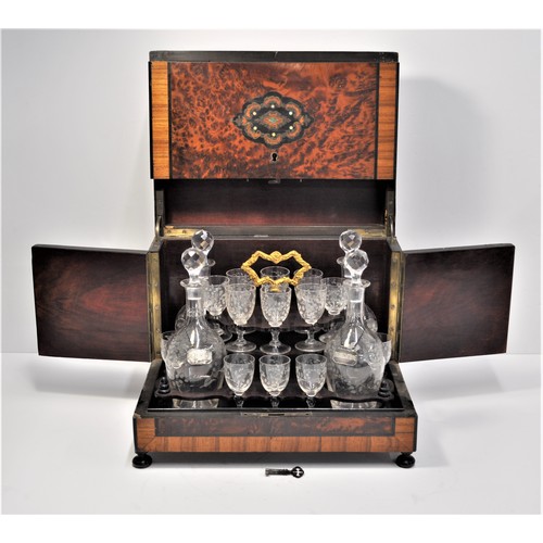 10 - Liqueur tantalus /cabinet containing four decanters, x16 glasses with flower designs. Top features m... 