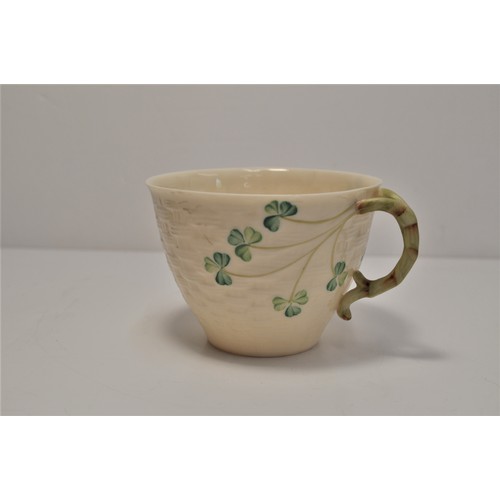 75 - A small group of Belleek pottery including cup and saucer, salt shaker, mug with lid including certi... 