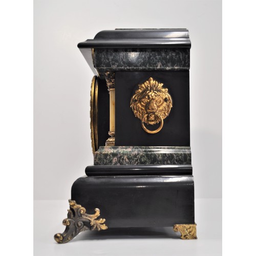 50 - An Antique Faux Slate, Ormolu, and Marble effect American Mantle Clock with twin columns and lion he... 