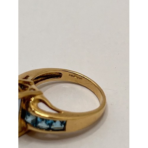 250 - 9ct yellow gold ring with faceted rectangular blue stone - possibly topaz, with co-ordinating square... 