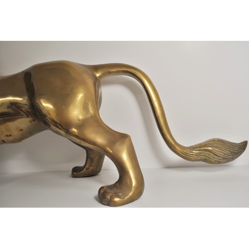 41 - Large roaring lion fireside statue in standing stance, approx height 41cm x 90cm. Very heavy item