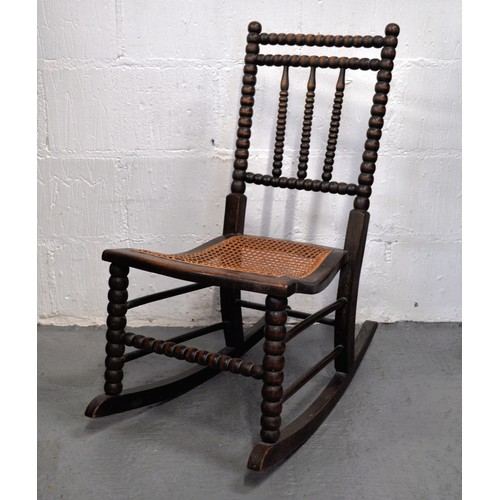 78 - Antique small bobbin turned rocking chair with  caned seat