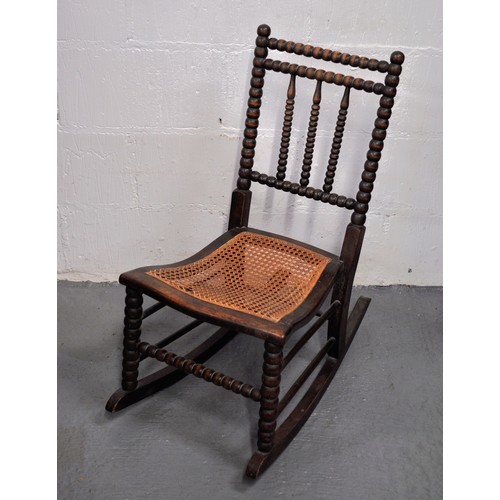 78 - Antique small bobbin turned rocking chair with  caned seat