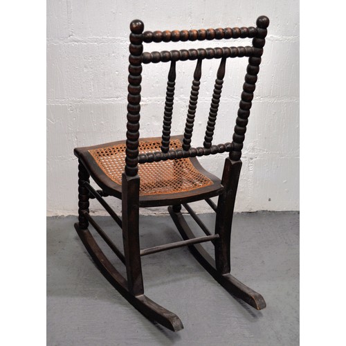 78 - Antique small bobbin turned rocking chair with  caned seat