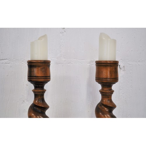 92 - Pair of chunky wooden pillar candle holders with a  barley twist and hand carved leaf design to stem... 