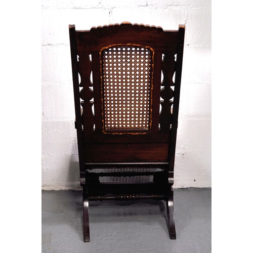 104 - Antique American style coil sprung cane rocking/rocker chair with carved detailing