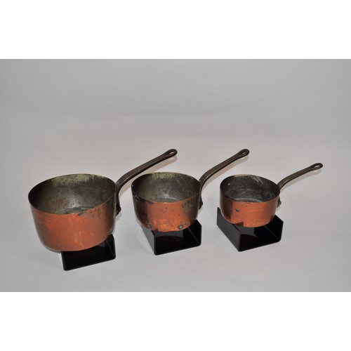 32 - Antique graduating copper saucepans with iron handles