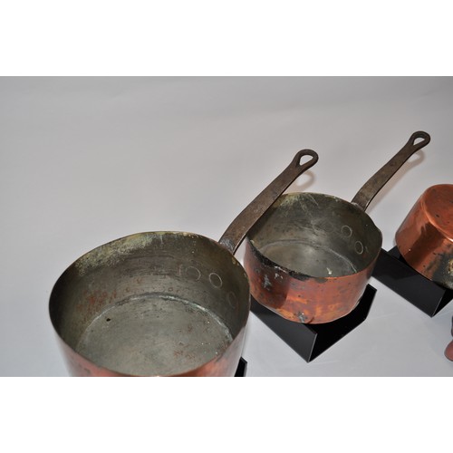 32 - Antique graduating copper saucepans with iron handles