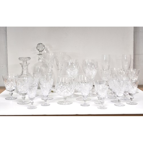 128 - A large quantity of mixed cut crystal glassware including a pair of Waterford Crystal champagne toas... 